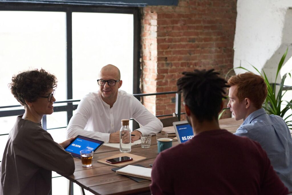 Équipe diversifiée collaborant dans un environnement de bureau moderne avec des ordinateurs portables et des notes sur la table.