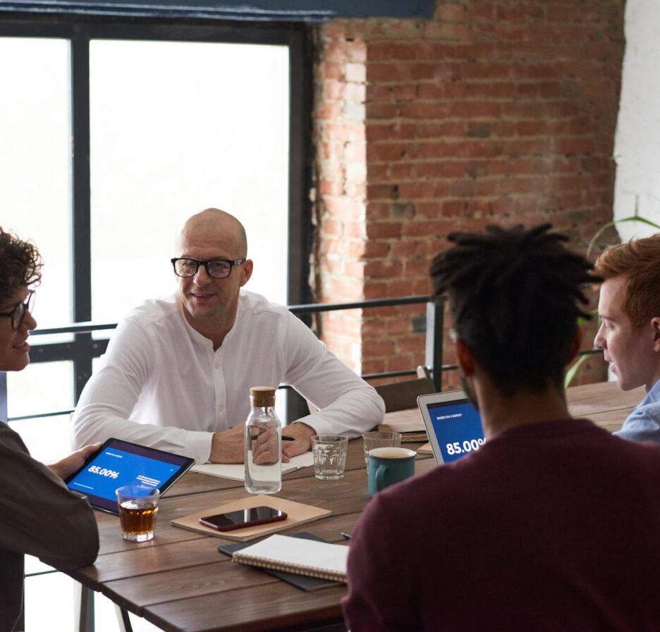 Équipe diversifiée collaborant dans un environnement de bureau moderne avec des ordinateurs portables et des notes sur la table.