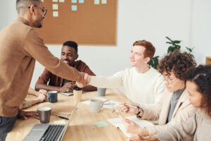 Une équipe diversifiée dans un bureau moderne travaillant ensemble sur un projet, mettant en valeur le travail d'équipe et la collaboration.