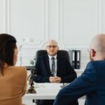 Réunion professionnelle en bureau avec trois individus