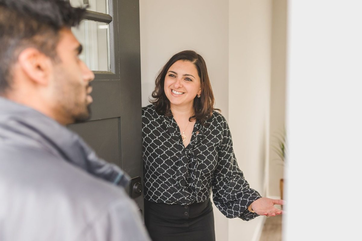 Femme souriant tend la main vers un homme dans un couloir
