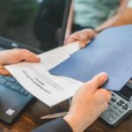 Échange de documents professionnels sur une table de bureau