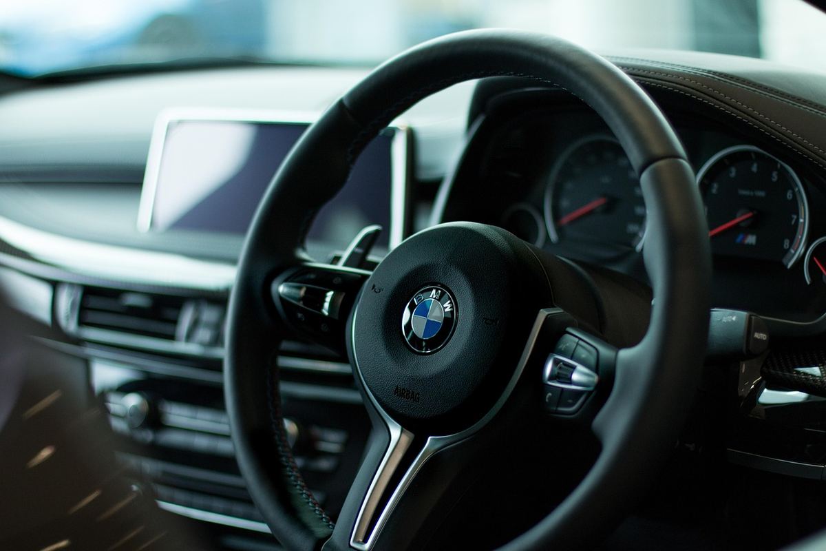 Intérieur d'une BMW, volant avec logo, tableau de bord et écran central visibles
